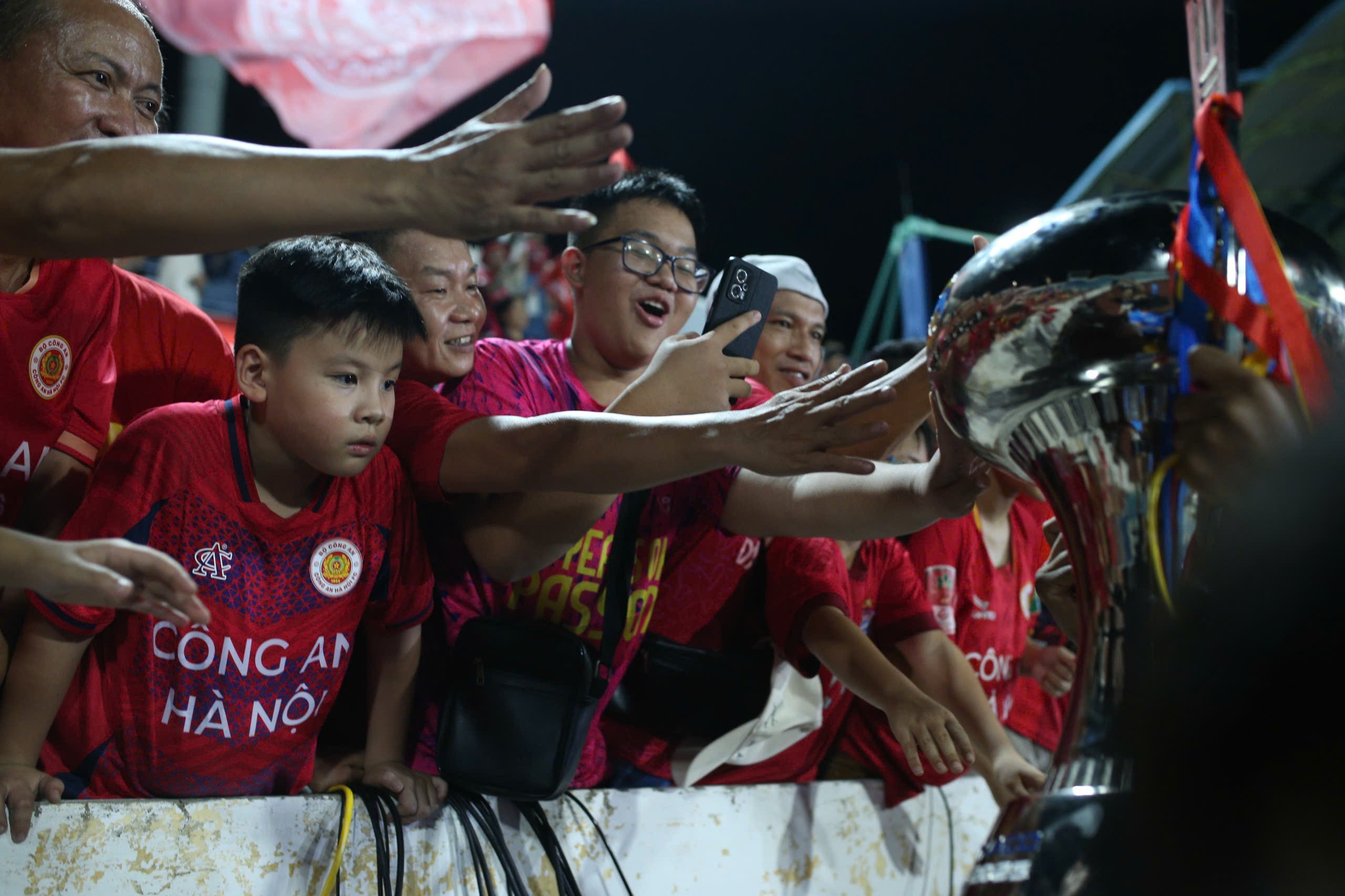 Các cổ động viên nhí của CLB Công an Hà Nội cố gắng chạm tay vào siêu cúp quốc gia