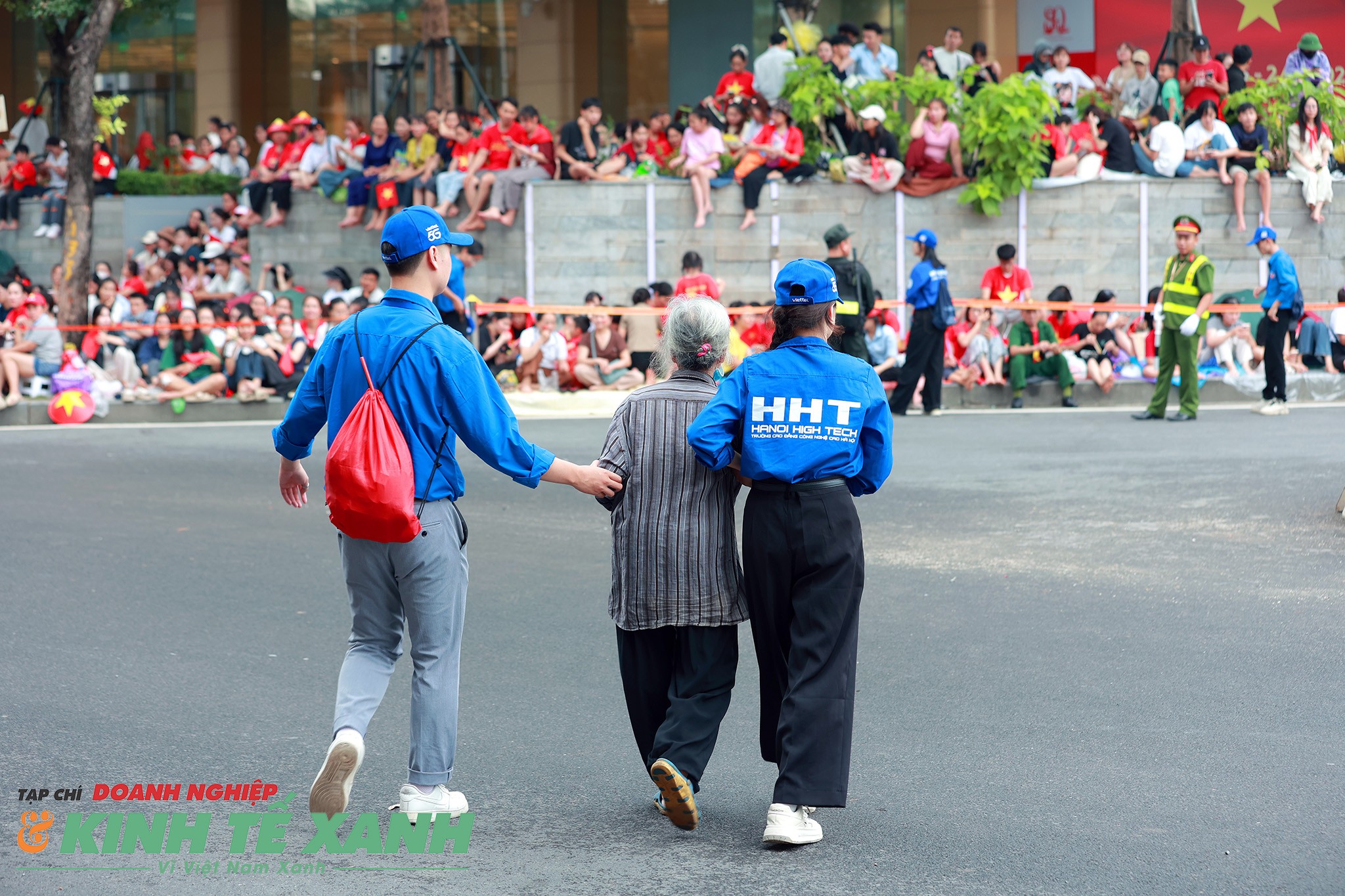 Thanh niên tình nguyện hỗ trợ, giúp đỡ bà cụ qua đường, tìm một chỗ ngồi thoải mái hơn để xem trọn vẹn buổi lễ