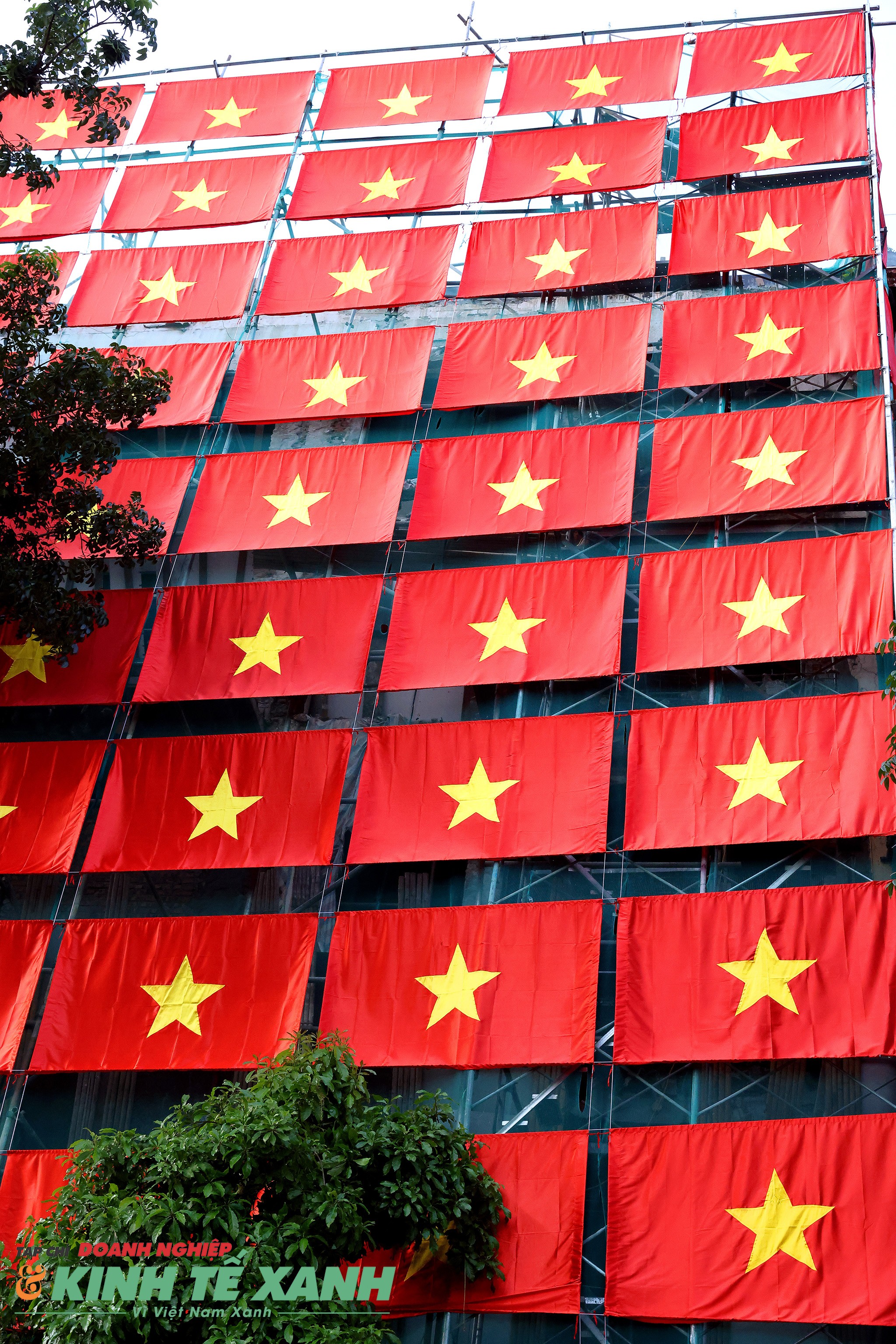 Cờ tổ quốc được phủ kín từ trên nóc xuống dưới chân công trình