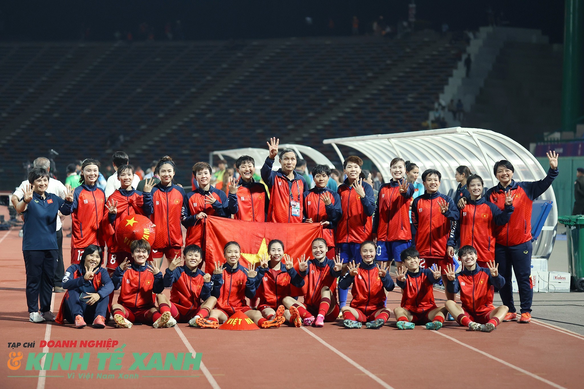 Ban Huấn luyện và các cầu thủ đội tuyển nữ Việt Nam tươi cười giơ 4 ngón tay, tượng trưng cho 4 lần liên tiếp giành huy chương vàng tại SEA Games