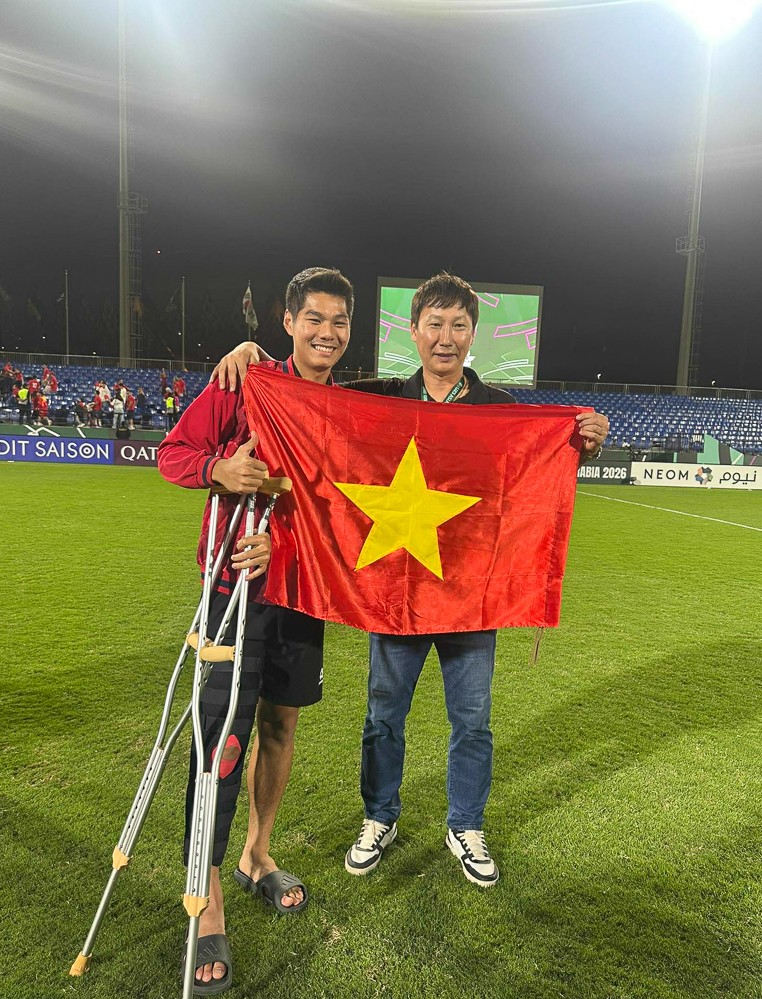 HLV Kim Sang Sik chụp ảnh chia vui cùng trung vệ Nguyễn Hiểu Minh - cầu thủ dính chấn thương nặng trong trận bán kết với U23 Trung Quốc