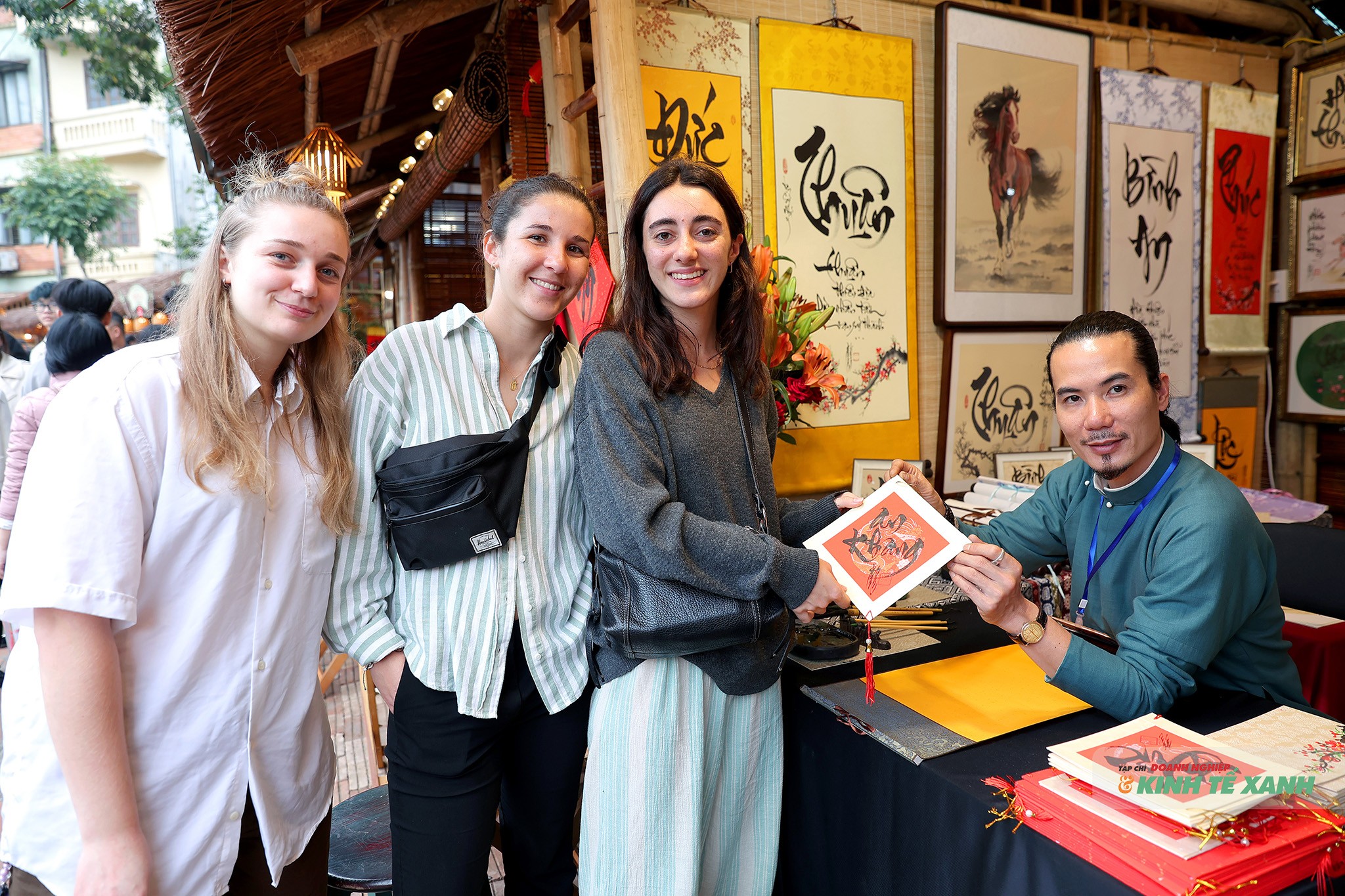 Ba du khách người Pháp chụp ảnh cùng ông đồ sau khi xin chữ An khang