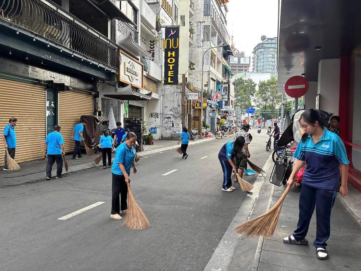 Ngay sau lễ phát động, nhân dân phường Bến Thành tham gia quét dọn vệ sinh đường phố tại tuyến hẻm trên đường Bùi Viện. 